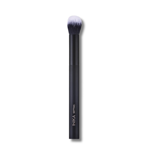 INIKA Organic Setting Brush with a slim black handle marked INIKA SETTING and dense soft ombre bristles from dark base to white tips.