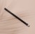 INIKA Organic Blending Brush on a beige background, with a slim black handle and rounded soft bristles in white and black tones.
