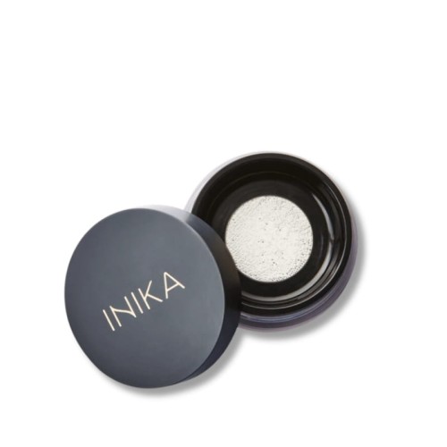 Round INIKA container with a black lid marked INIKA and a light loose or pressed powder inside.