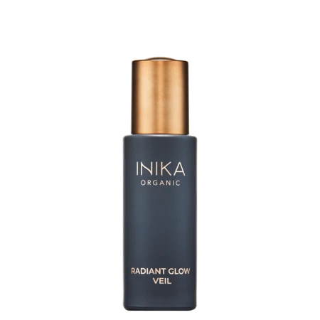 INIKA Organic Radiant Glow Veil in an elegant dark matte glass bottle with a metallic gold cap.