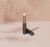 INIKA Organic Lip Balm standing upright on an elegant beige and pink background.