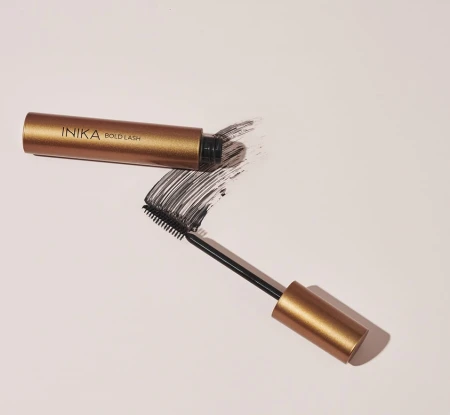 Open INIKA Organic Bold Lash Mascara with a bold black mascara swatch on a light background.