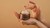 Hands holding INIKA Organic Overnight Repair Treatment and taking a small amount of the silky cream formula.
