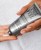 Hand squeezing white INSTYTUTUM Triple Action Resurfacing Peel onto the palm from a silver tube.