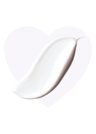 Smooth white eye cream texture spread in an elongated drop shape on a light heart background.