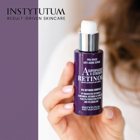 Hand holding purple INSTYTUTUM Superpacked X-Strength Retinol serum with white pump and silver cap.
