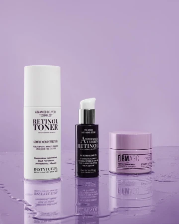 Three INSTYTUTUM retinol care products on a glossy purple background with water drops.
