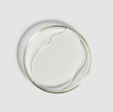 Clear ENVIRON Sebu-ACE Oil sample in a flat glass dish.