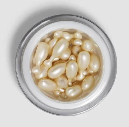 Top view of an open ENVIRON Hydrating Oil Capsules jar filled with pearly capsules.