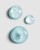 Close-up of blue gel serum droplets with bubbles on a grey background.