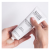Hands squeezing INSTYTUTUM Transforming Melting Cleanser from a white tube onto the palm.