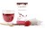 Glass of red Rooibos Strawberry tea with SAROOBOS carton, tea bags, fresh strawberry and golden spoon.