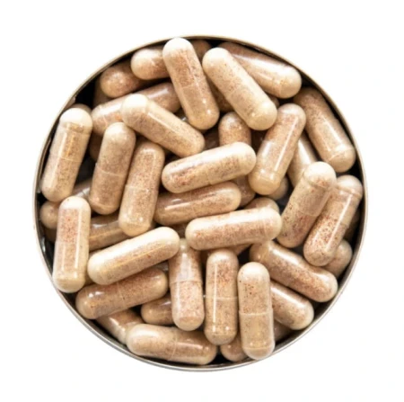 Round metal tin filled with semi-transparent beige supplement capsules on a white background.