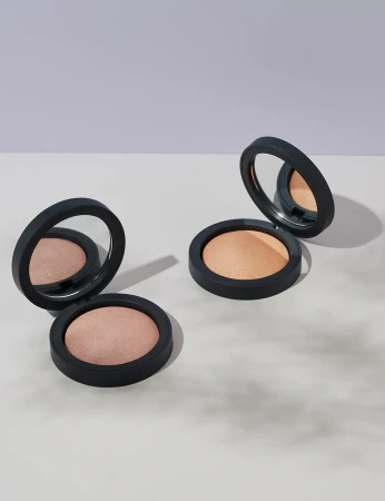 Open INIKA Organic Baked Illuminisor compacts showing STARLIGHT on the left and DEWDROP on the right.