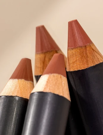 Close-up of several INIKA Organic Lip Crayon tips showing beige, nude and brown tones.