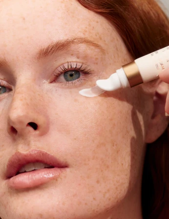 Woman applying INIKA Organic Phytofuse Renew Eye Cream directly under the eye with the precision applicator.