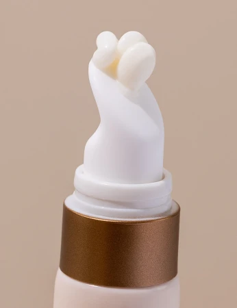 Cream emerging from the curved white applicator tip of INIKA Organic Phytofuse Renew Eye Cream.