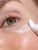 Close-up of INIKA Organic Phytofuse Renew Eye Cream being applied along the lower eye area.