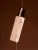 INIKA Organic Adaptogenic Cleansing Oil bottle with a flowing stream of oil against a warm dark background.