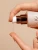 Clear INIKA Organic Adaptogenic Cleansing Oil texture flowing onto fingertips during application.