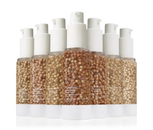 Jane Iredale HydroPure Tinted Serum bottles in multiple shades with white pump dispensers.