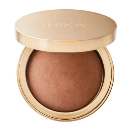 Open satin-gold INIKA Organic compact showing the warm SUNBEAM baked bronzer shade.