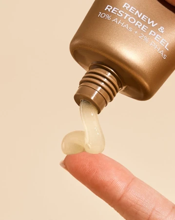 INIKA Organic Renew & Restore Peel gel being dispensed from the copper tube onto a fingertip.