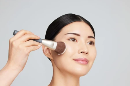 Jane Iredale Multiuse Blending Brush applying powder to a model's face.