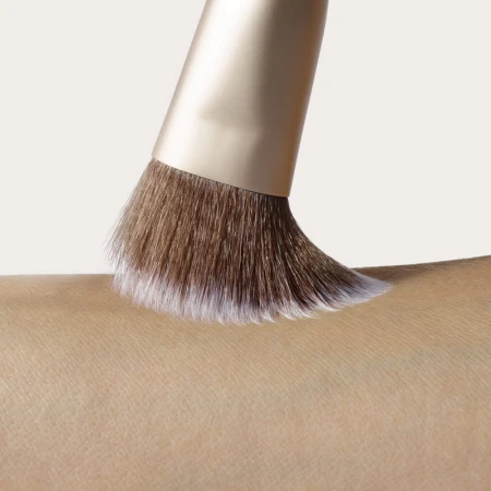 Close-up of a soft Jane Iredale cheek brush sweeping across skin.