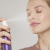 Woman misting her face with Jane Iredale Lavender Hydration Spray for a refreshed, calm-looking complexion.