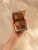 Open INIKA Organic Quad Eyeshadow Palette FLOWERS held in a hand with beige, brick, burgundy and brown shades.