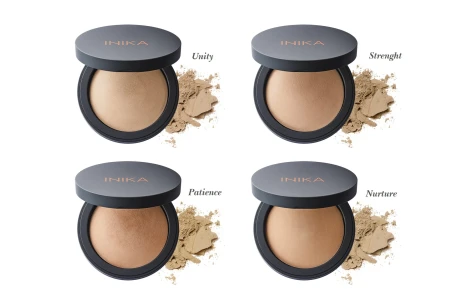 Four open INIKA Organic Baked Mineral Foundation compacts with loose powder beside each shade.