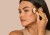 Model applying cream bronzer under the cheekbone for soft contour.