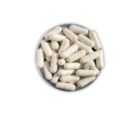Open Colostrum-C tin showing beige capsules layered inside the container.