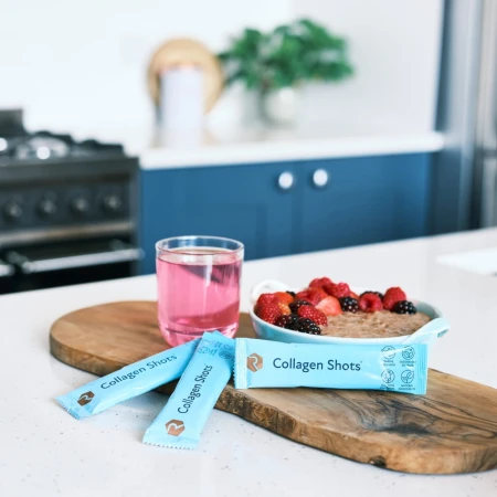 Breakfast scene with oatmeal, pink drink and Rejuvenated Collagen Shots sachets.