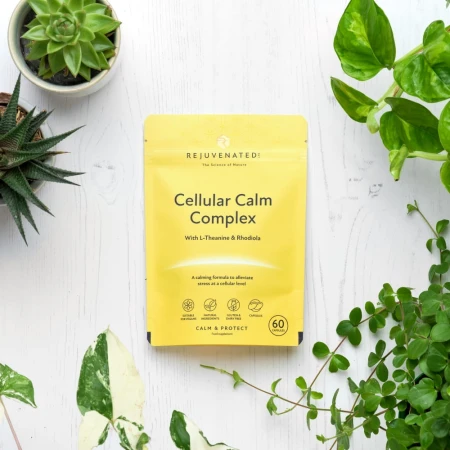 Rejuvenated Cellular Calm Complex yellow-beige capsule pack surrounded by green plants.