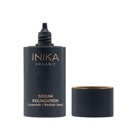 Open INIKA Organic Serum Foundation with elegant navy packaging and gold accents.