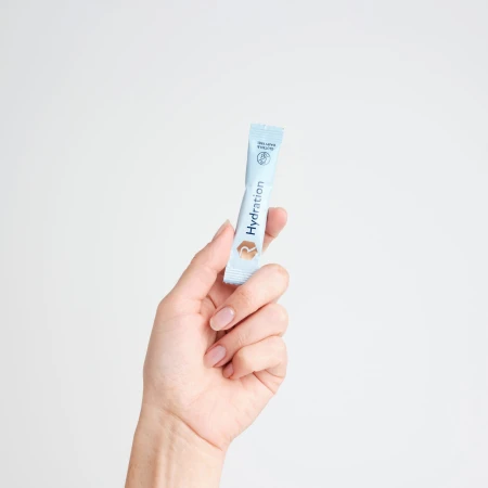 Hand holding blue Rejuvenated H3O Hydration sachets.