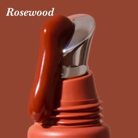 Cooling metal applicator with INIKA Organic Tinted Lip Serum in the Rosewood shade.