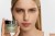 Model holding INSTYTUTUM SuperBiotic Regenerating Cream jar, highlighting smooth radiant-looking skin.
