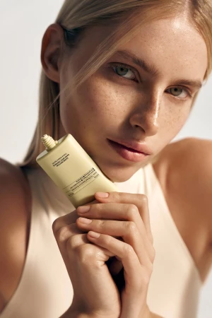 Model holding INSTYTUTUM Sunscription Dark Spot Defence SPF50 tube with applicator visible
