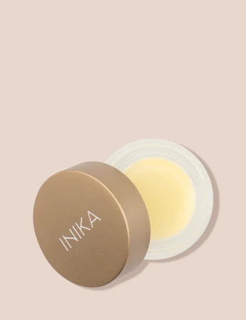 Open INIKA Organic Lip Mask jar with gold lid and pale yellow nourishing formula