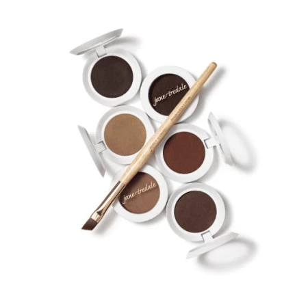 Jane Iredale brow styling powders: five round pots with white lids, opened to show brow powder shades from light beige through warm brown to deep dark brown.