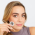 Woman in natural makeup presenting Jane Iredale PureBrow Brow Powder with a brow powder and brush in her hand. Her brows look fuller and softly defined.