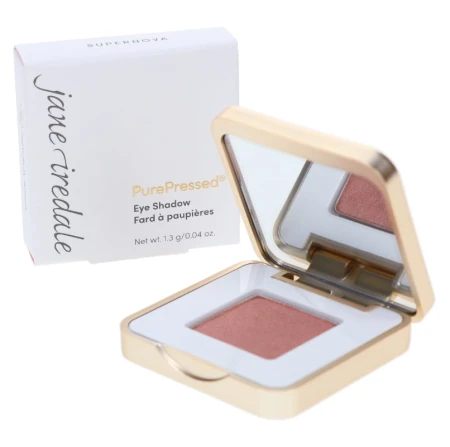 Jane Iredale PurePressed Eye Shadow in Supernova, a metallic warm pink with a copper note and subtle shimmer in a half-open white and gold compact.